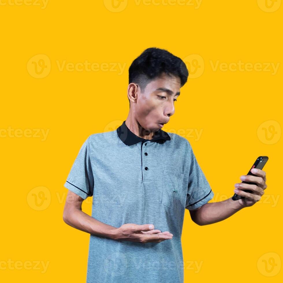 sorpreso viso di giovane asiatico uomo puntamento a il vuoto fotocopia spazio con un' sorpreso viso, indossare un' grigio foto