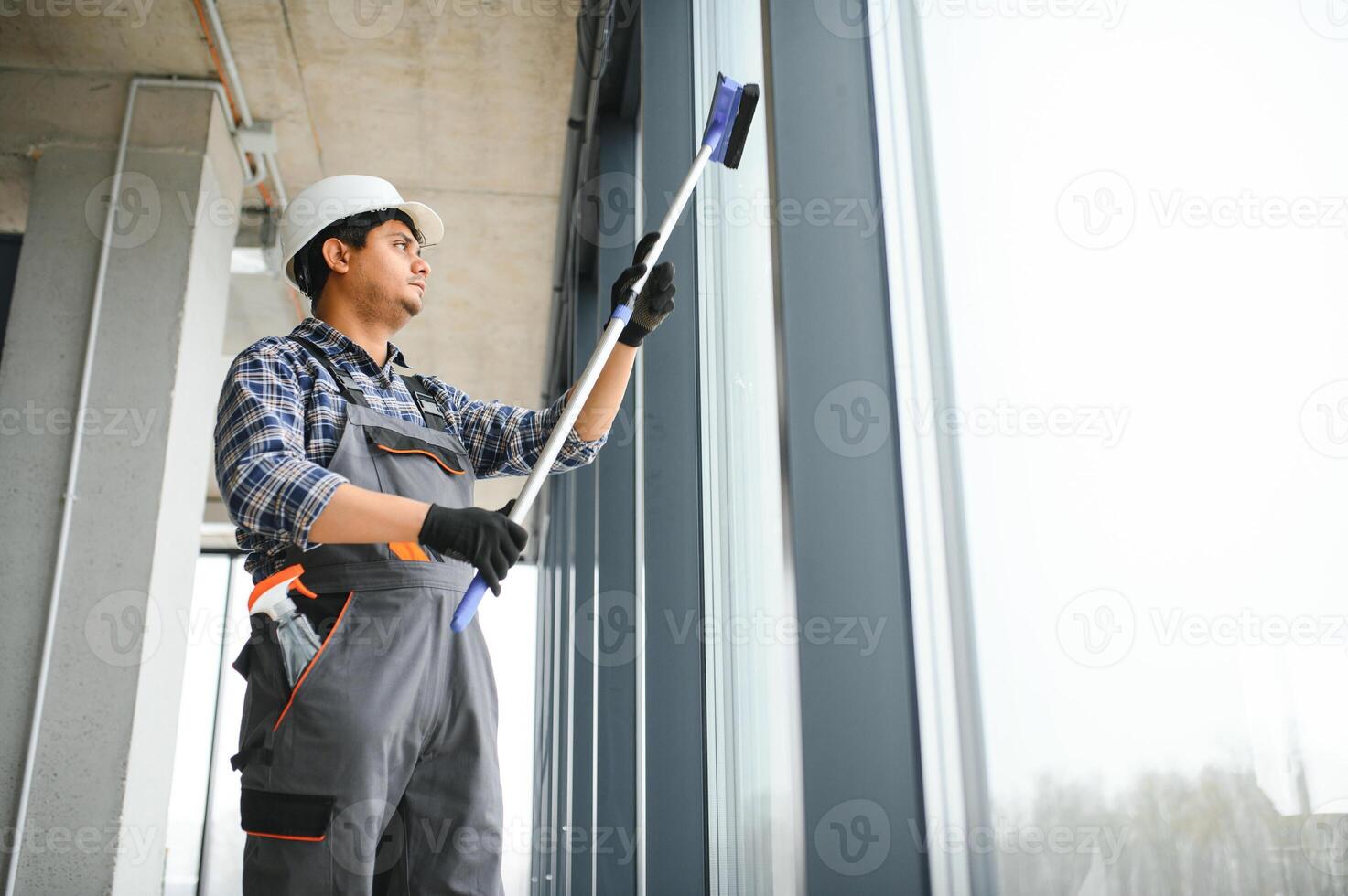 maschio professionale pulizia servizio lavoratore pulisce il finestre e negozio finestre di un' memorizzare con speciale attrezzatura foto