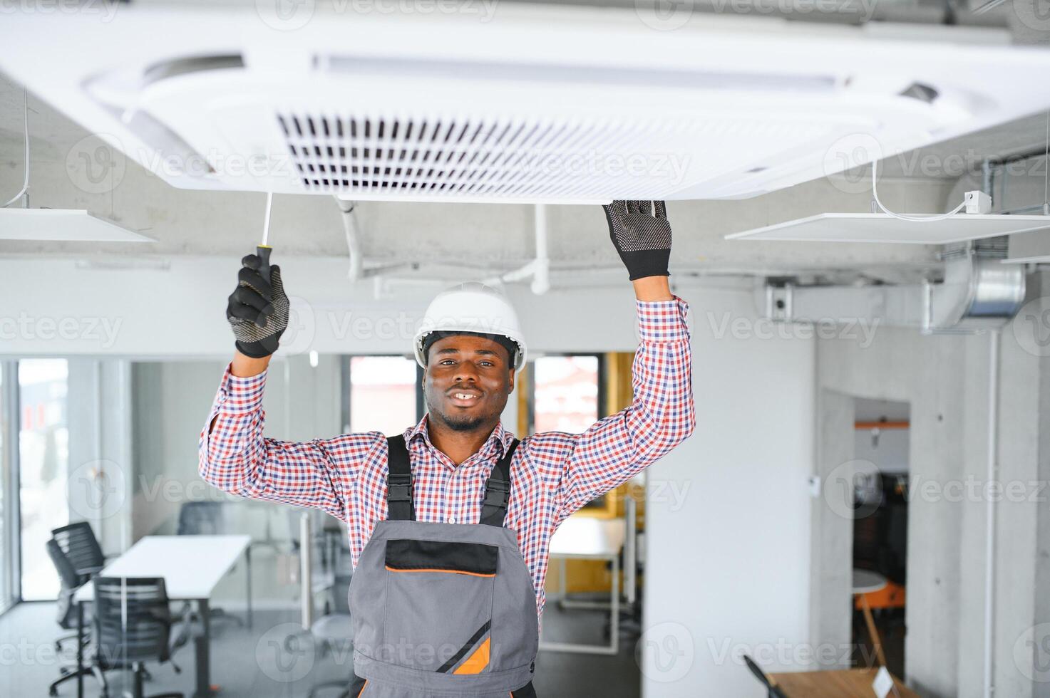 contento giovane africano maschio tecnico riparazione aria condizionatore foto