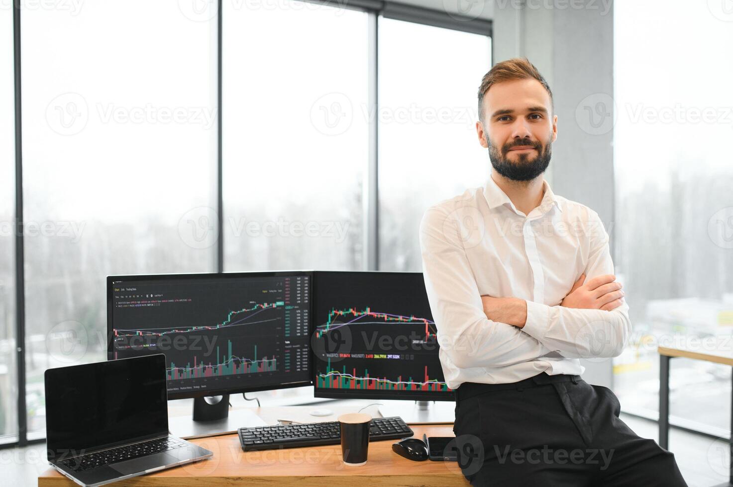 crypto commerciante si siede a il suo posto di lavoro nel davanti di un' tenere sotto controllo con grafici. foto