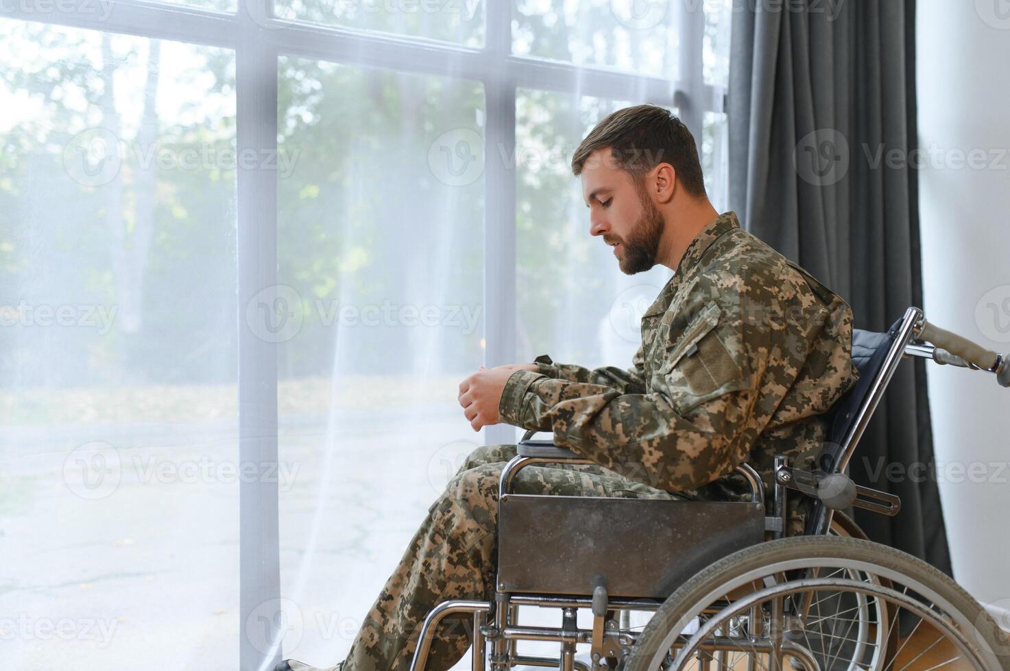 bello soldato seduta nel un' sedia a rotelle su grigio sfondo foto