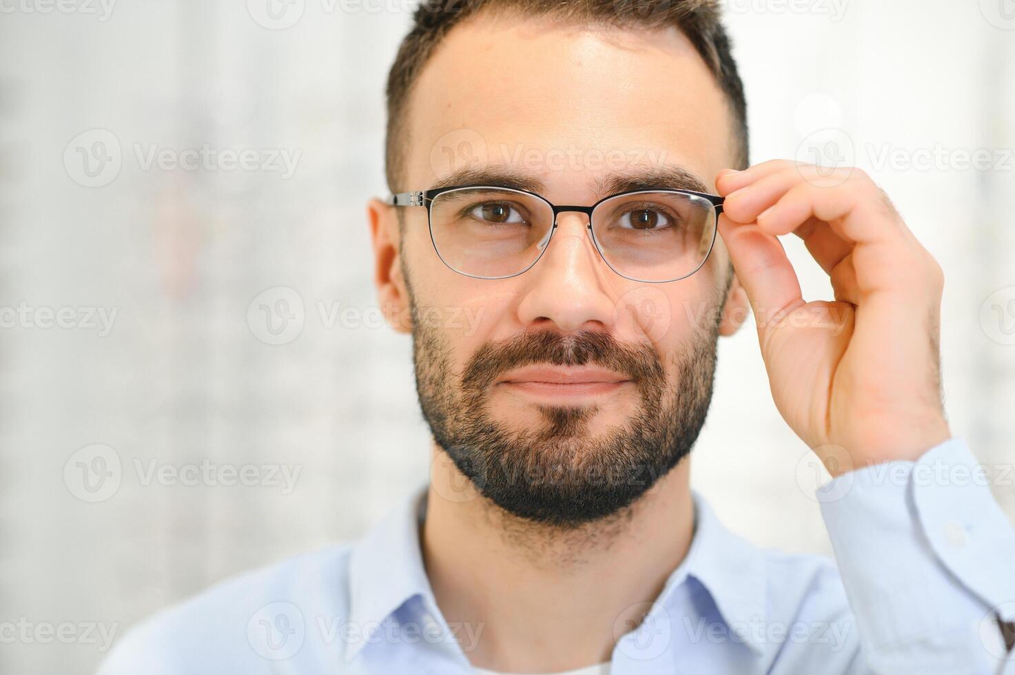 bicchieri negozio. uomo provando su occhiali nel ottica memorizzare foto