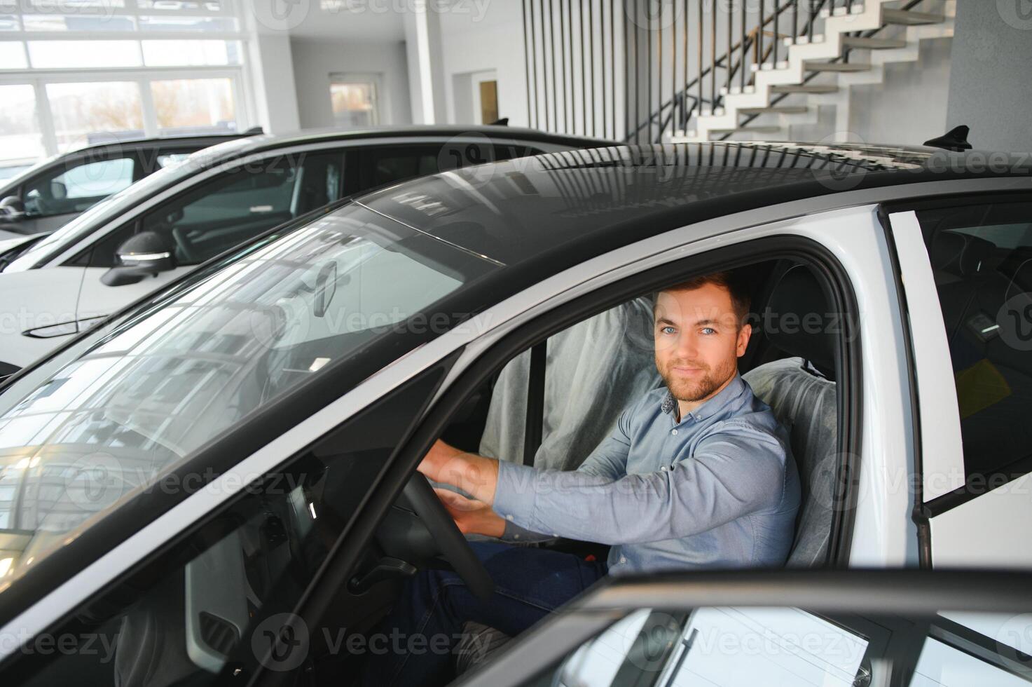 giovane uomo, vendita elettrico macchine nel il showroom. concetto di acquisto eco-friendly auto per famiglia foto