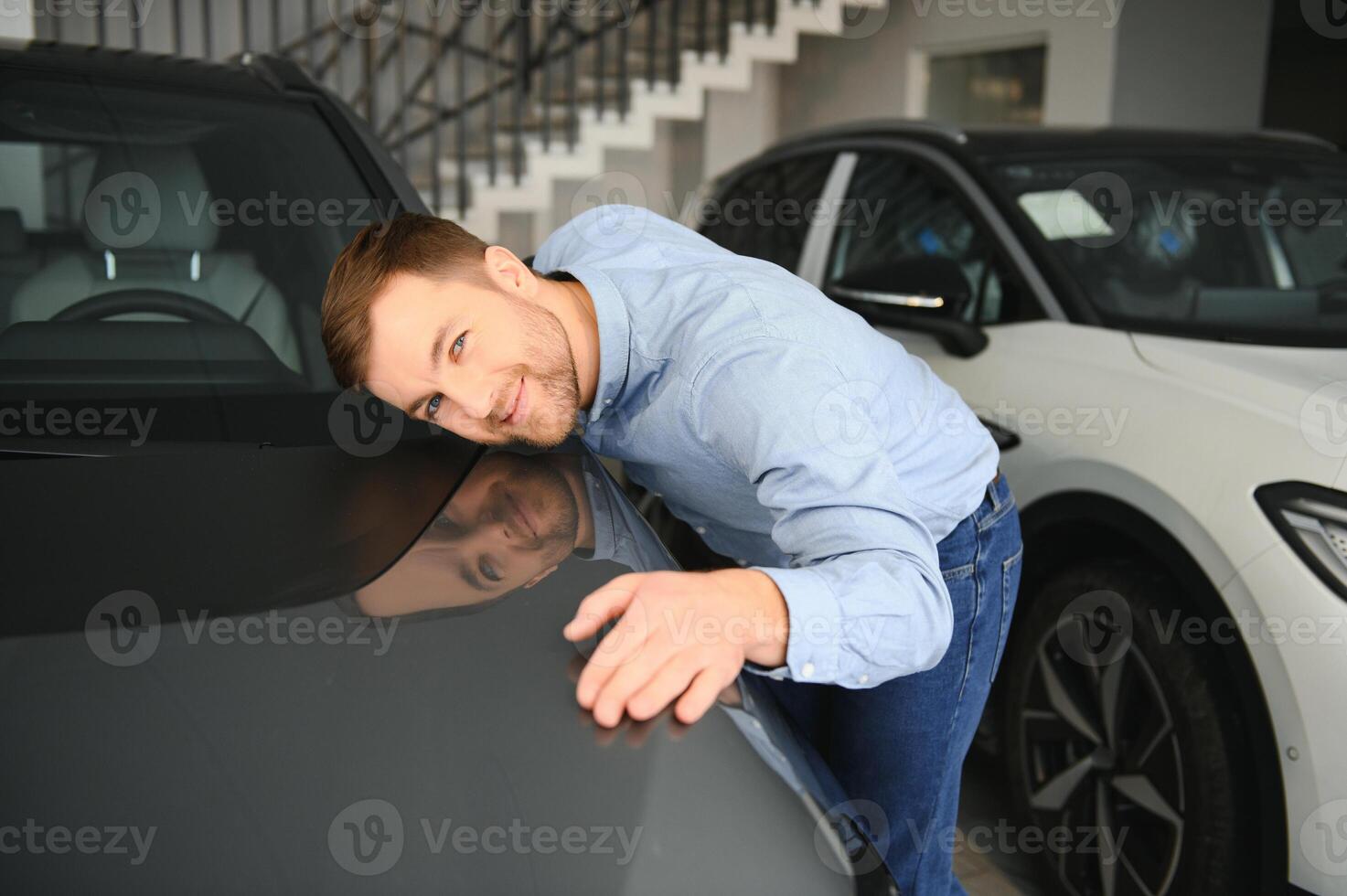 un' contento uomo sceglie un' nuovo elettrico auto a un' auto concessionaria. il concetto di acquisto un ecologico auto foto