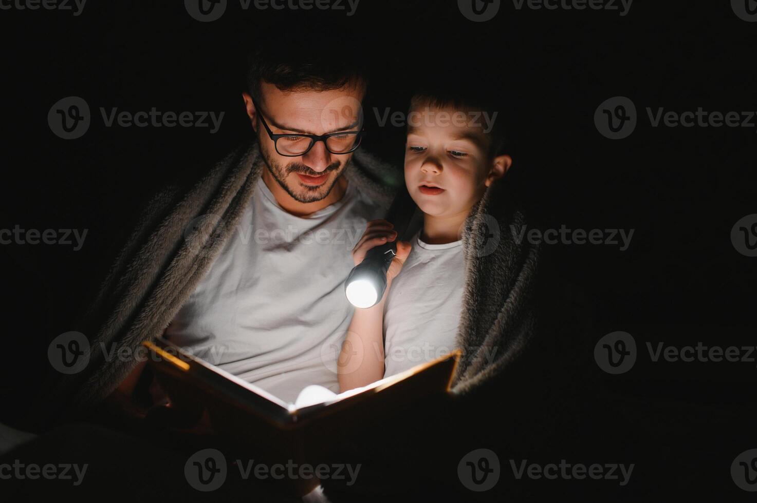 contento famiglia lettura di andare a dormire storia sotto coperta nel sera. padre e figlio trascorrere tempo insieme. Il padre di giorno foto