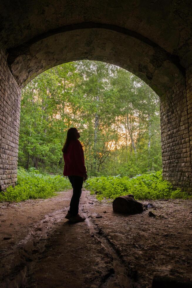 02 di giugno 2023 - Kazan, Russia - ragazza a piedi attraverso un' buio tunnel per il Uscita. leggero a il fine di il tunnel. foto
