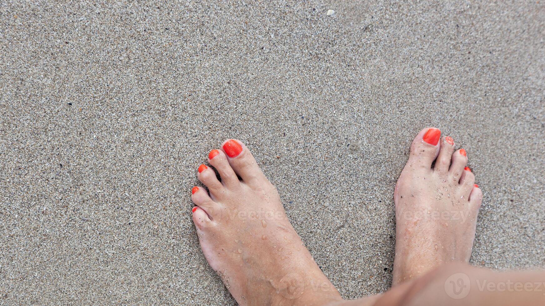 Da donna piedi con un' pedicure nel il sabbia su il spiaggia foto