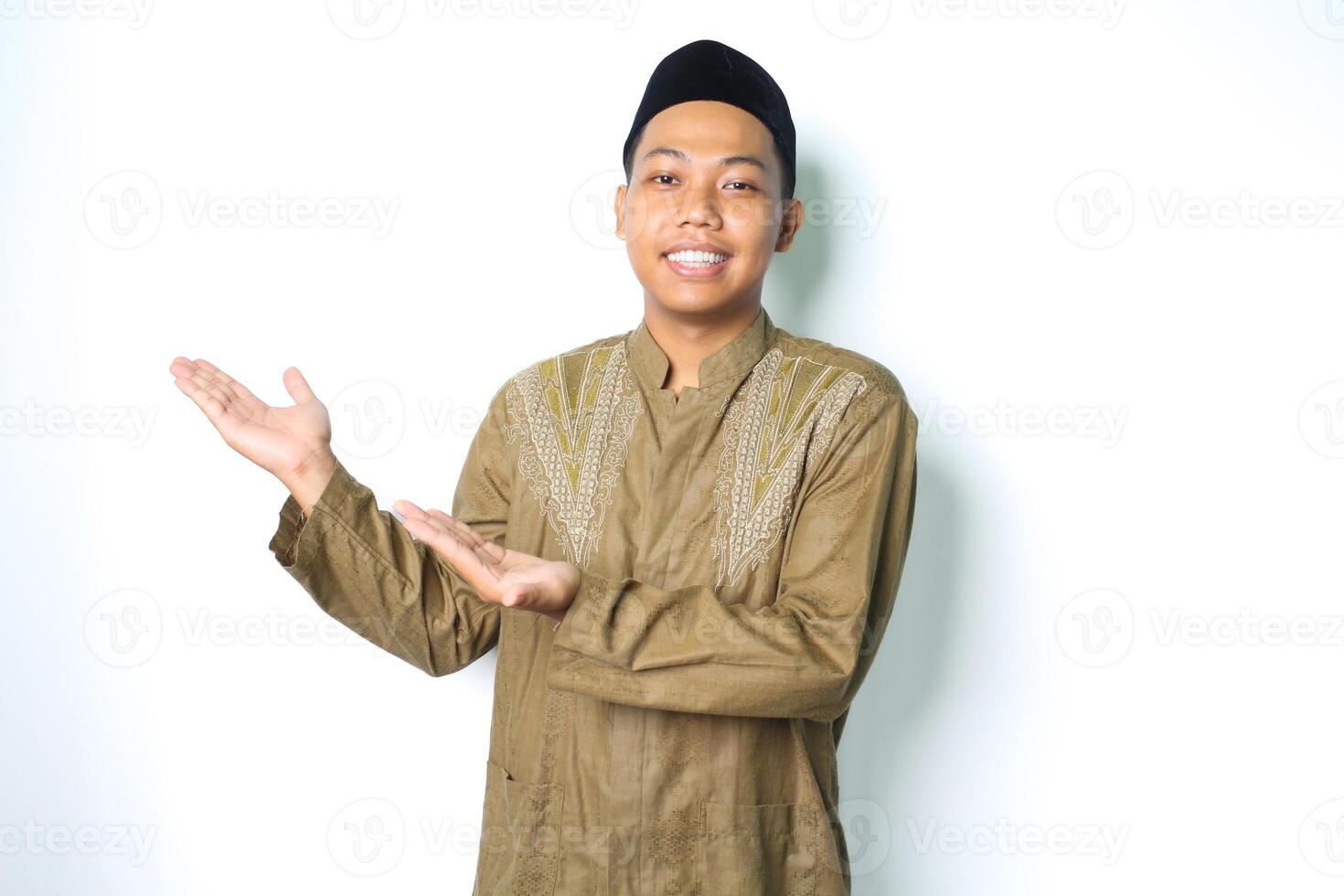 sorridente asiatico musulmano uomo indossare islamico vestito presentazione vuoto spazio isolato su bianca sfondo foto