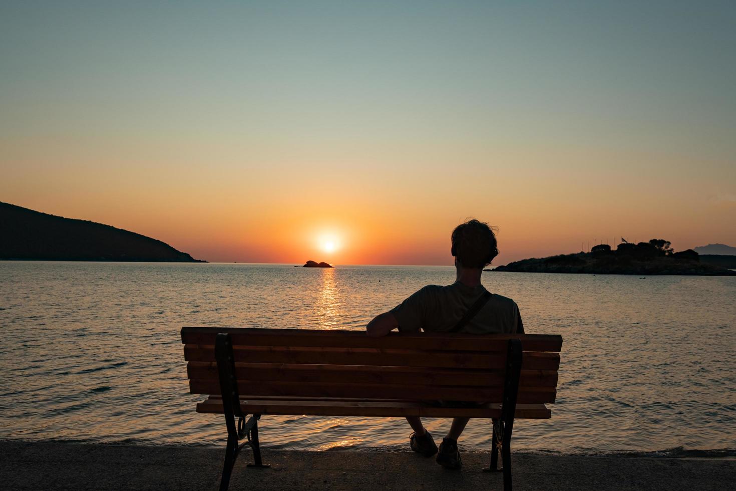 sagoma di un uomo sullo sfondo del tramonto in riva al mare foto