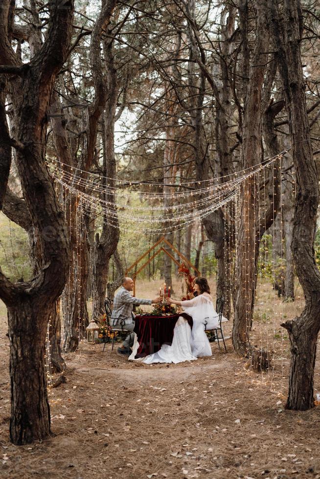 cena di nozze di una coppia di sposini nel bosco autunnale foto