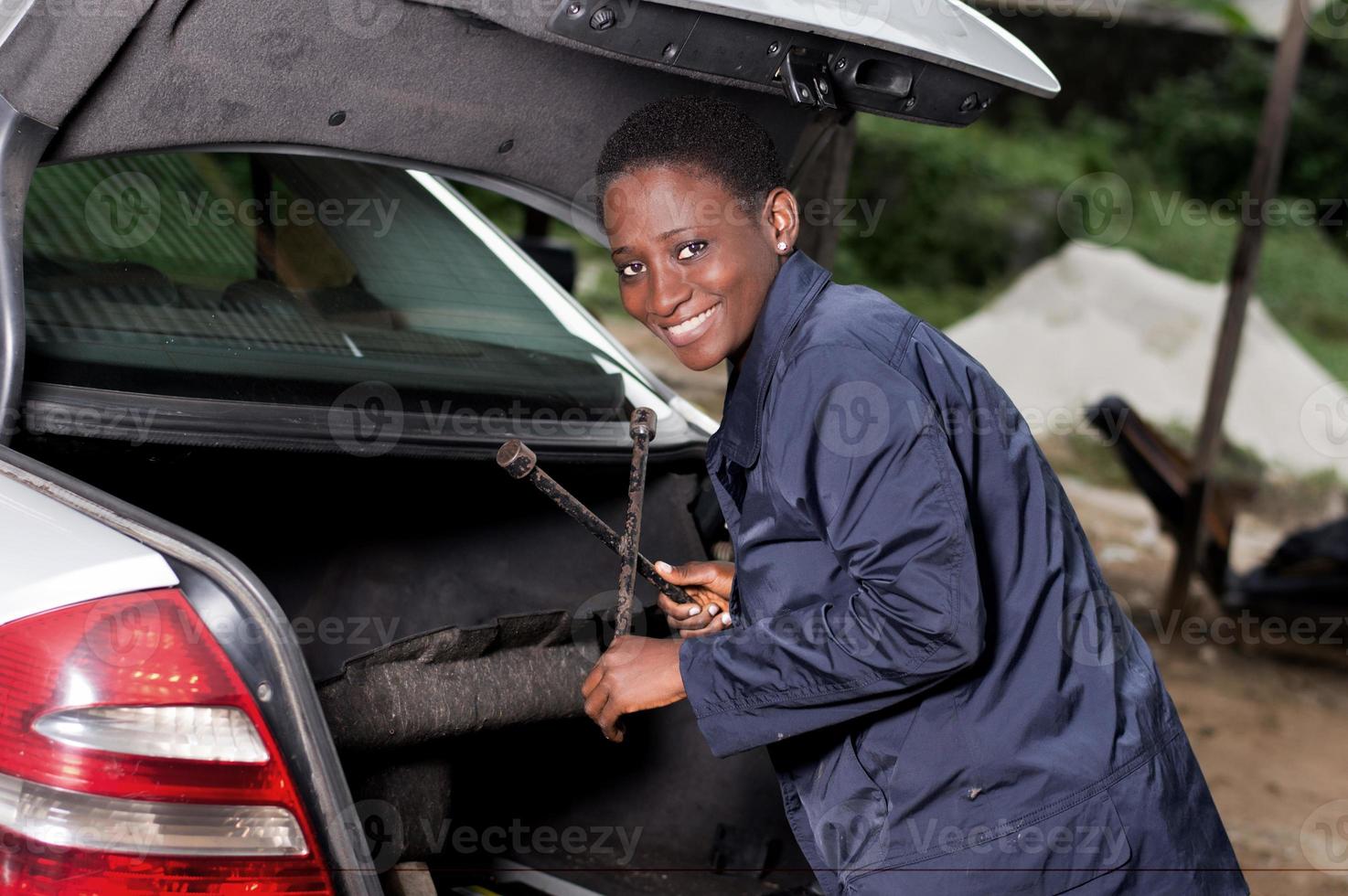 giovane meccanico sorridente con uno strumento di lavoro. foto