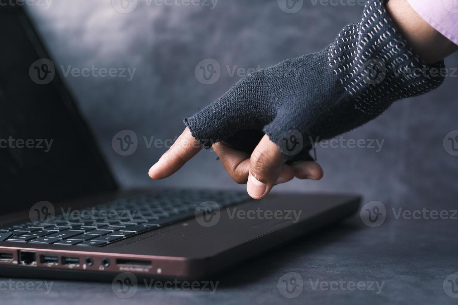 mano di hacker che ruba dati dal laptop foto