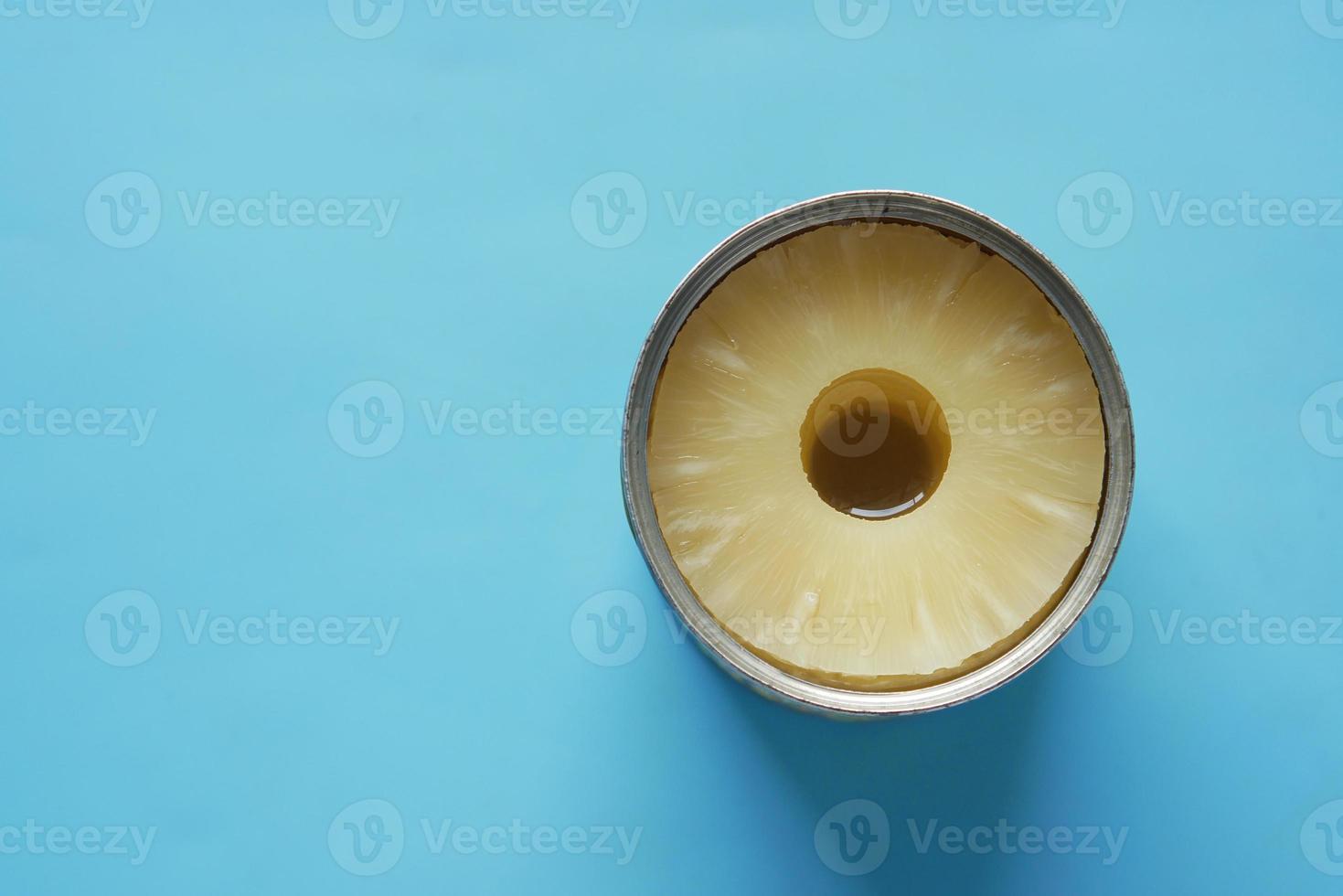una lattina aperta di ananas sul tavolo con copia spazio foto