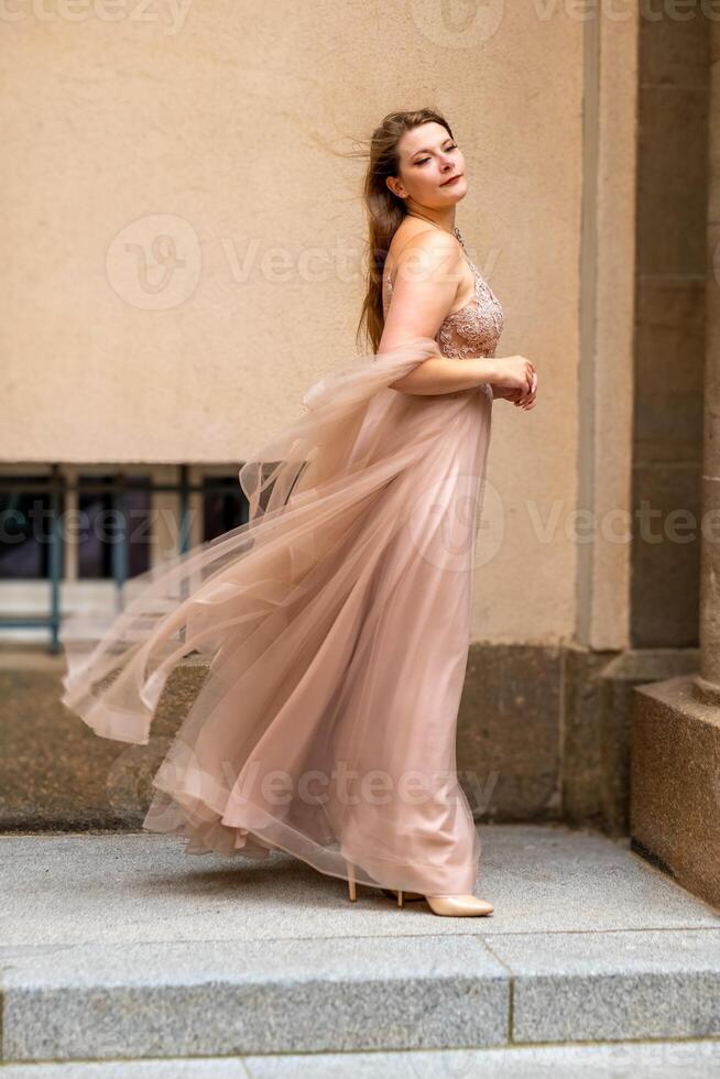 un' donna nel un' crema colorato vestito come un' Principessa nel il vento foto