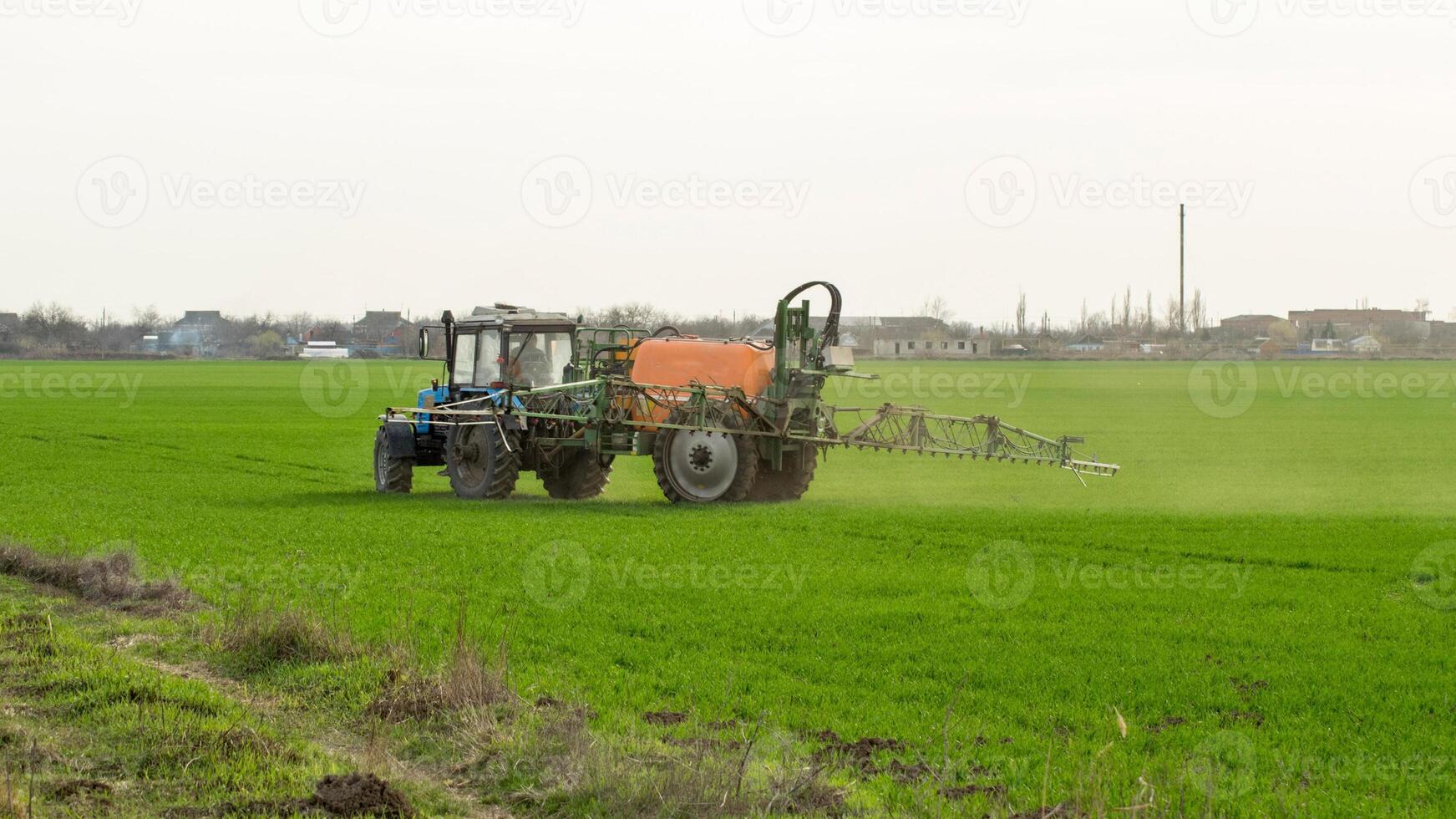 trattore con un' spray dispositivo per finemente disperso fertilizzante. foto