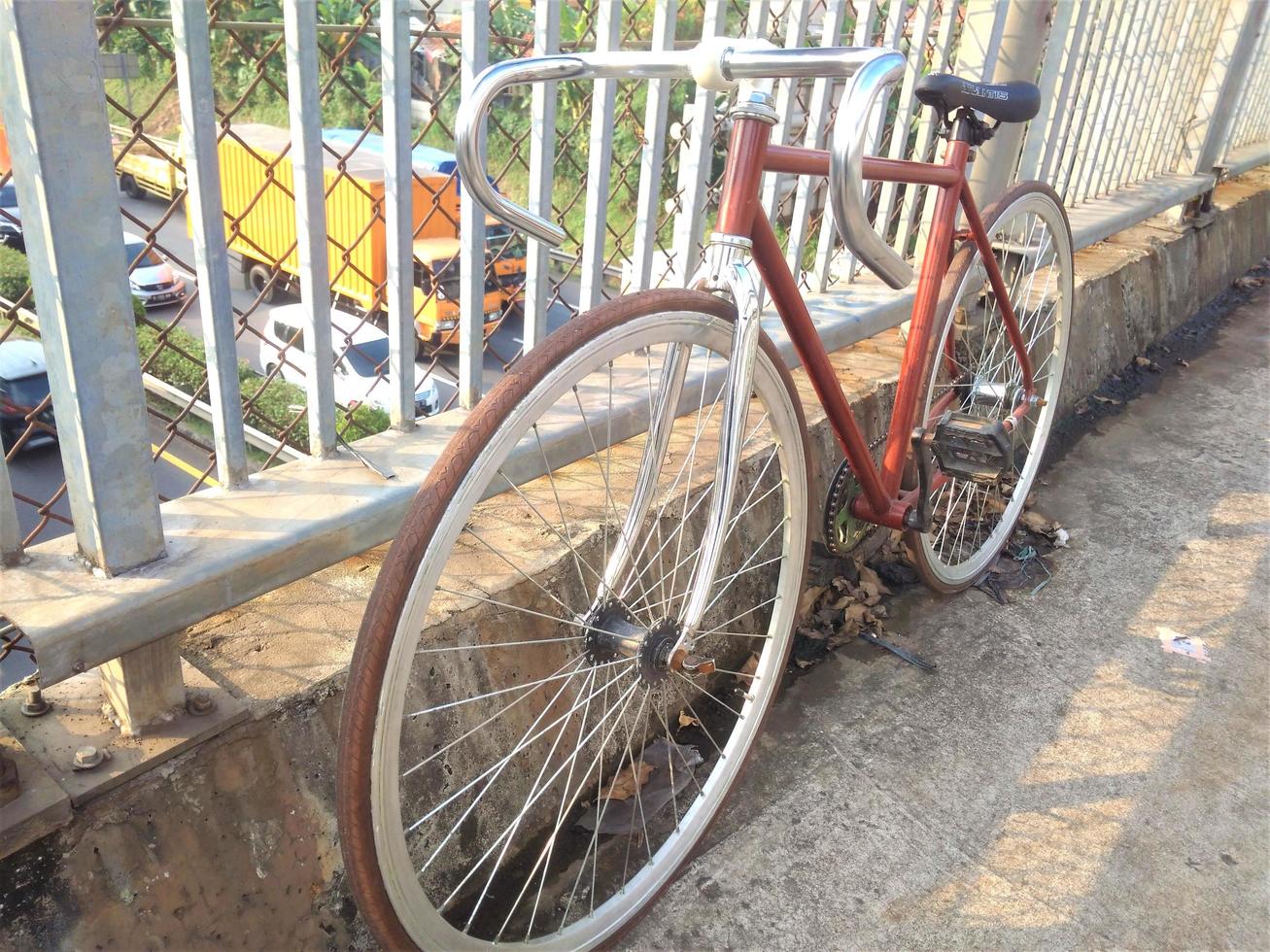 una bicicletta parcheggiata su un ponte pedonale foto