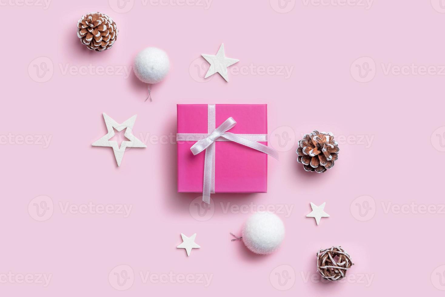regalo di natale e decorazioni. semplice composizione natalizia su superficie rosa pastello. vista dall'alto, posizione piatta foto