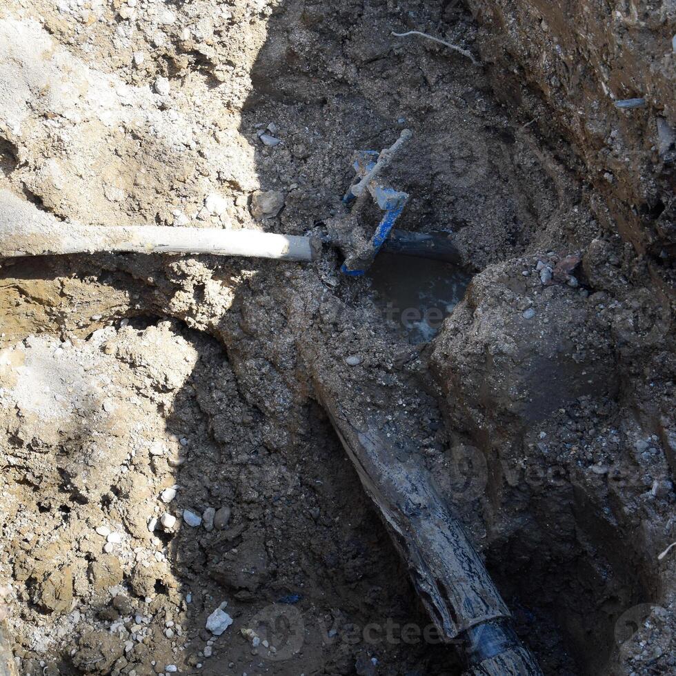 un scavato fossa con un' danneggiato tubatura. riparazione di comunicazioni. foto