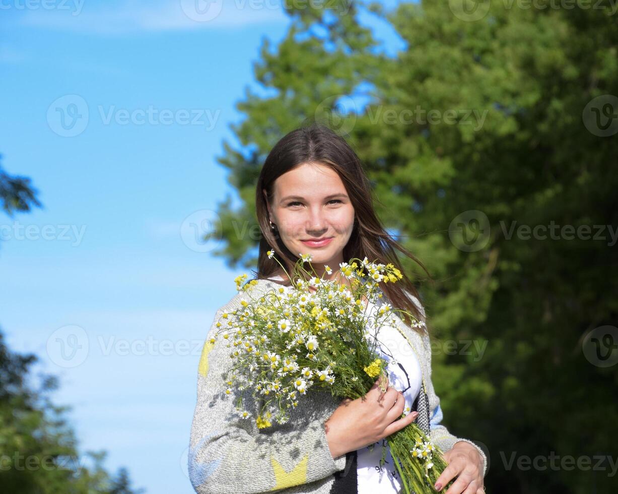 giovane bellissimo ragazza con un' mazzo di camomilla. un' donna nel un' foto