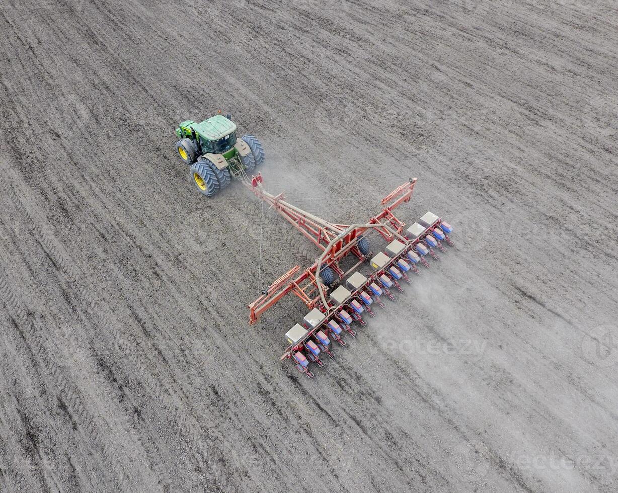 semina di Mais. trattore con un' seminatrice su il campo. utilizzando un' seminatrice per piantare Mais. foto