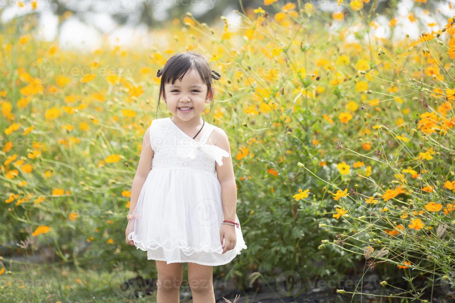 un' contento giovane ragazza ammira e delicatamente tocchi e ammira un' fioritura fiore. esso riflette il bellezza di primavera e il semplice piaceri di essere nel contatto con natura. primavera risveglio. foto