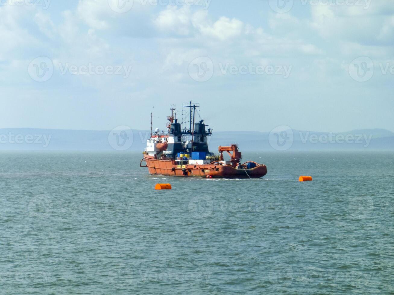 un' piccolo servizio nave nel un' carico industriale porta. un' nave nel il mare foto