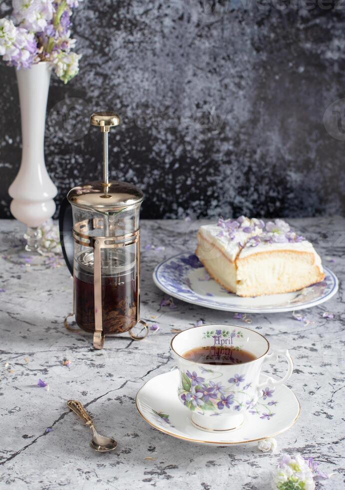 ancora vita con nero tè e formaggio torta, primavera profumo,delicato lilla fiori foto