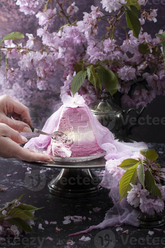 tradizionale Pasqua ortodosso cagliata torta con sakura fiori, donna decorazione cibo foto