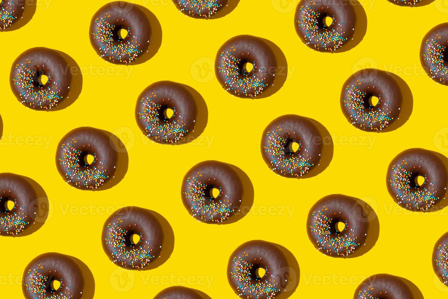 cioccolato ciambelle modello su giallo sfondo. superiore Visualizza, piatto posare foto