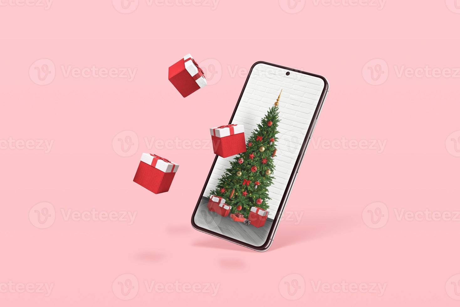 telefono con albero di natale e regali che escono dal display. concetto minimale con colore rosa pastello sullo sfondo foto