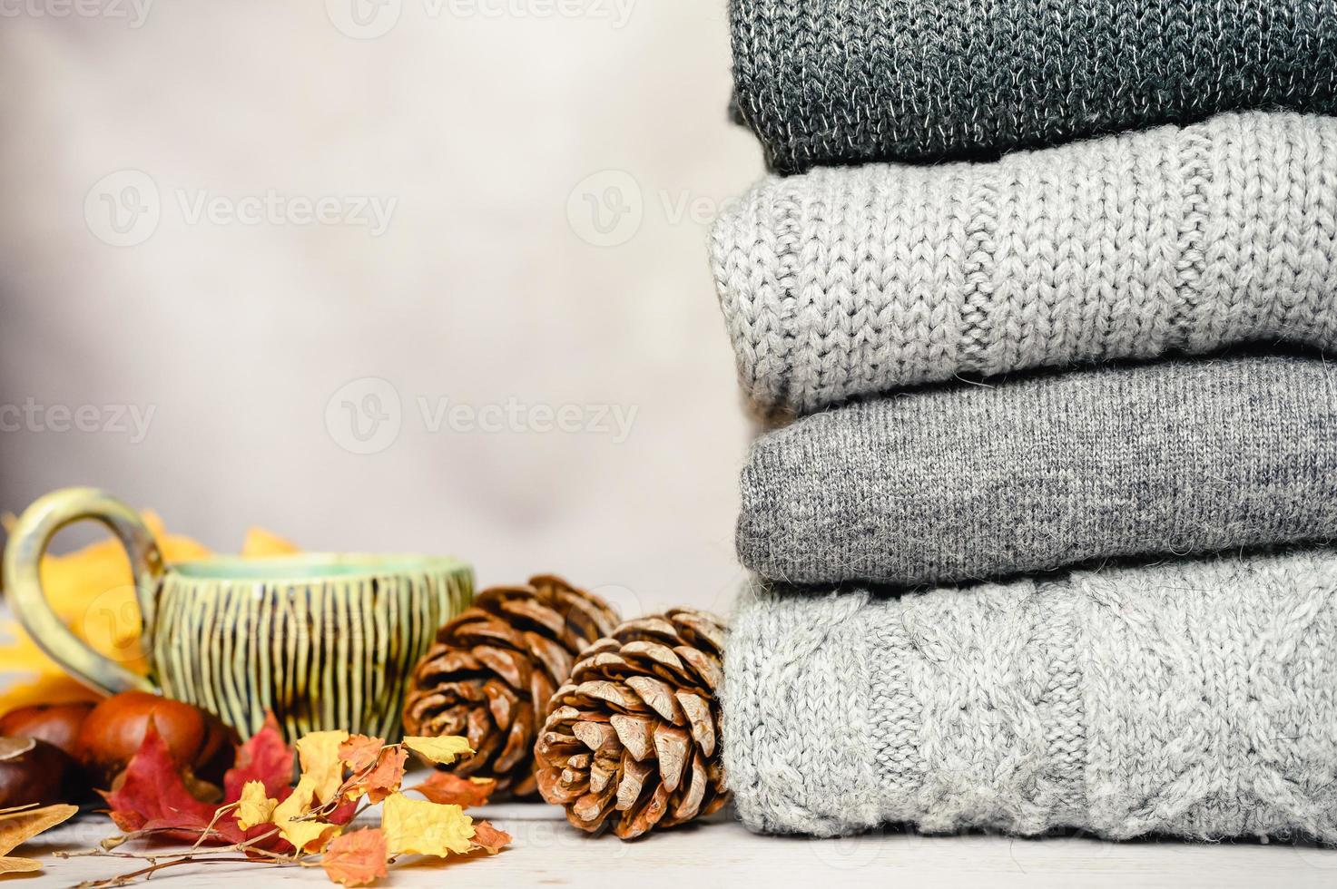 foglie di acero gialle e rosse autunnali sullo sfondo di un maglione lavorato a maglia grigio accogliente foto