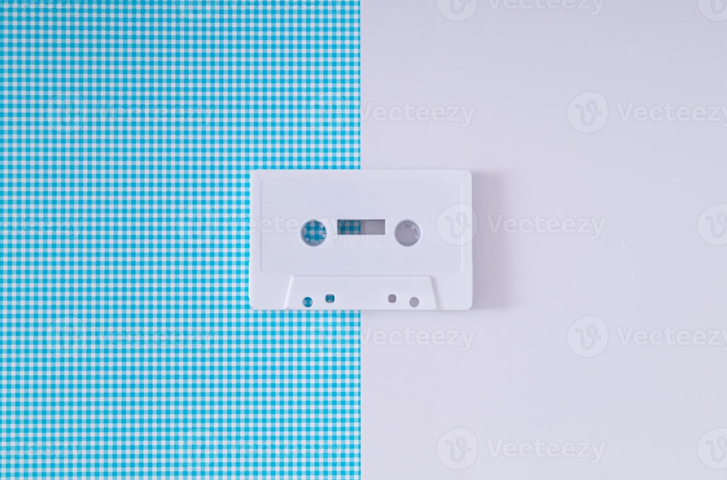 disposizione di retrò bianca Audio cassetta nastro su bianca e blu sfondo. creativo concetto di vecchio tecnologia. anni 80 estetico. Vintage ▾ Audio cassetta nastro idea. retrò moda nostalgia. retrò futurismo. foto