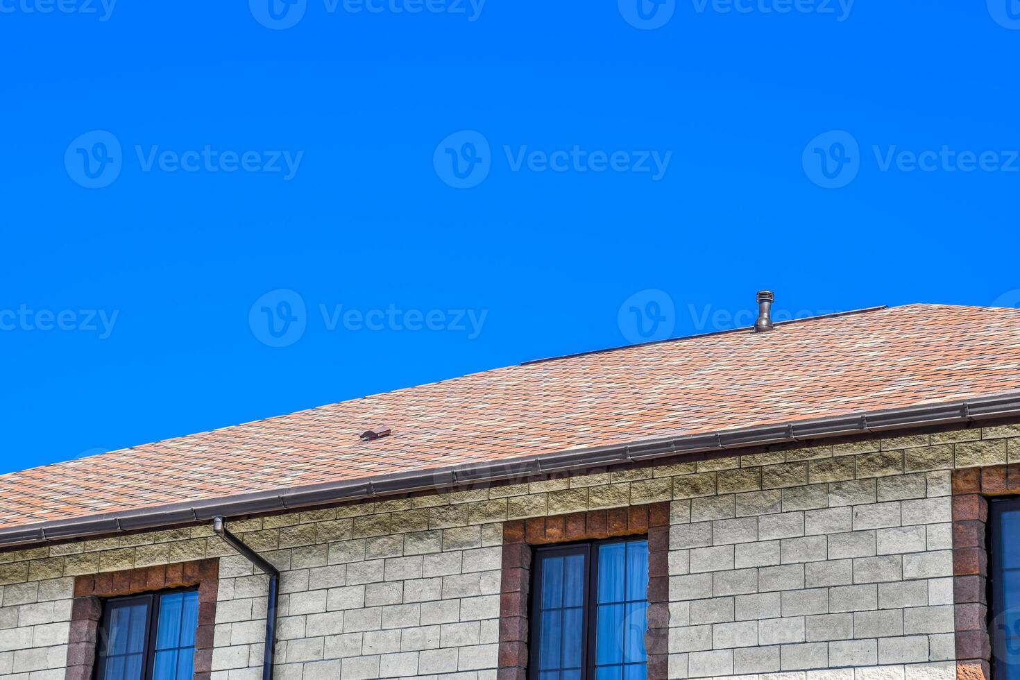 il Casa è fatto di beige mattoni, il tetto è coperto con bitume herpes zoster. metallo plastica finestre su il Casa. foto