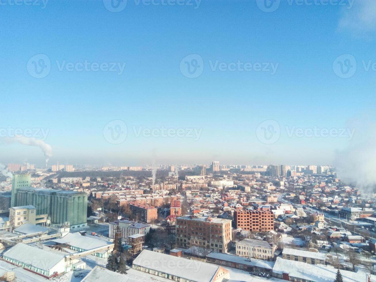 inverno cittadina. gelido soleggiato giorno nel il città. neve su il strade e Fumo a partire dal il caldaia si alza. brina e sole, un' meraviglioso giorno foto