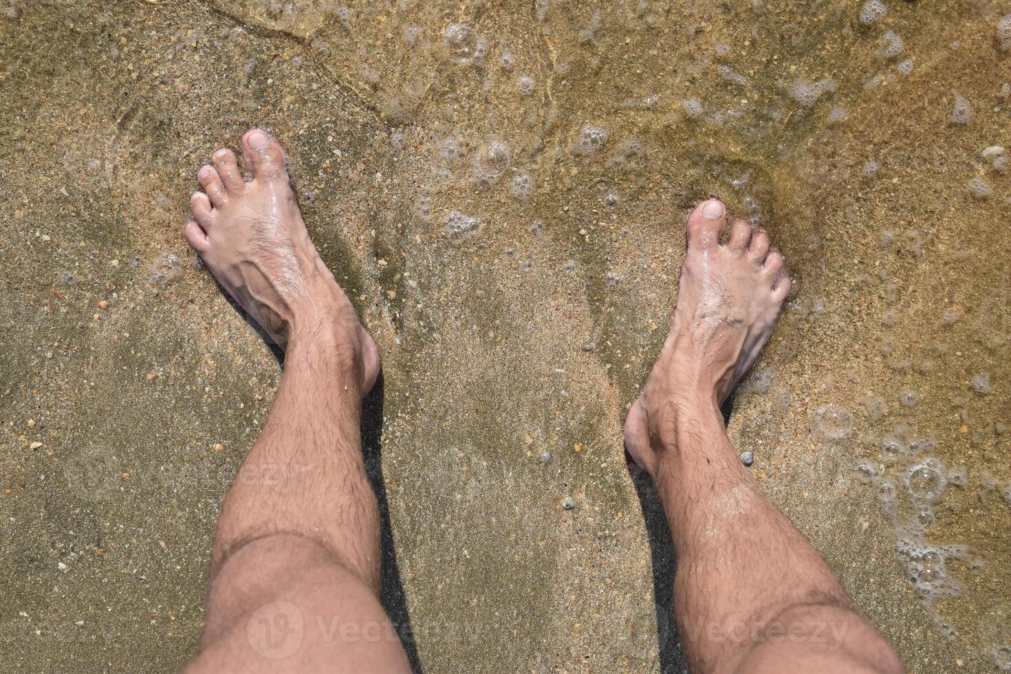 gambe uomini su il mare sabbia vicino mare onda foto