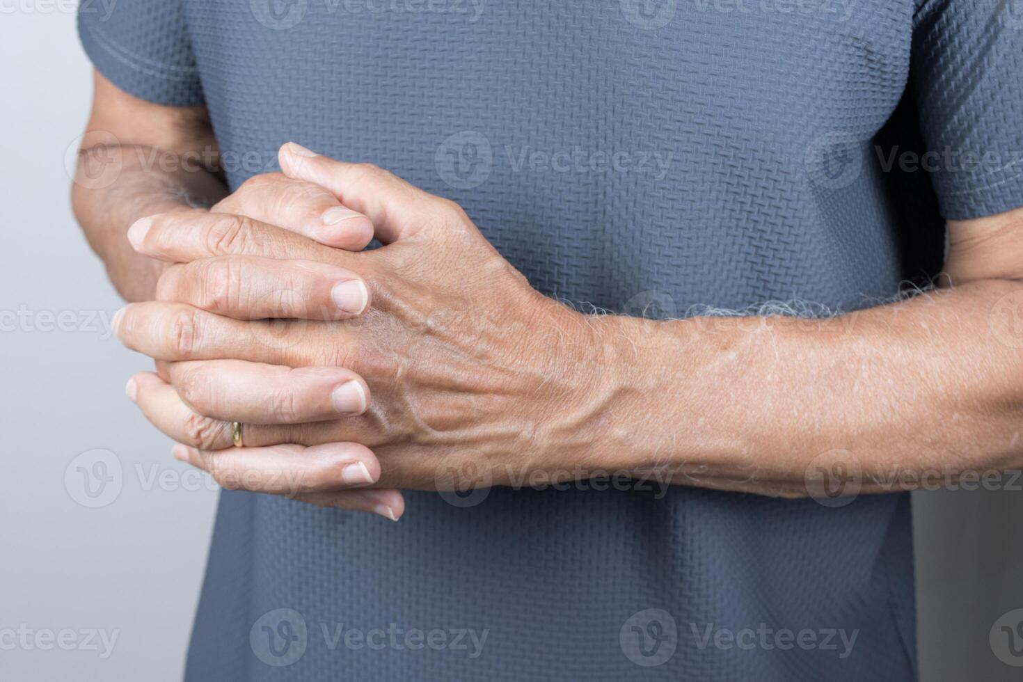 uomo Tenere il suo mani piegato nel davanti di lui foto