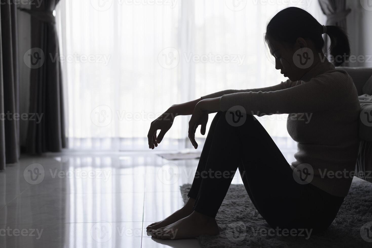 silhouette di un' persona sofferenza a partire dal depressione nel il Casa, depresso donna seduta solo su il divano sentire fatica, triste e preoccupato nel il buio camera. persona siamo stressato. foto