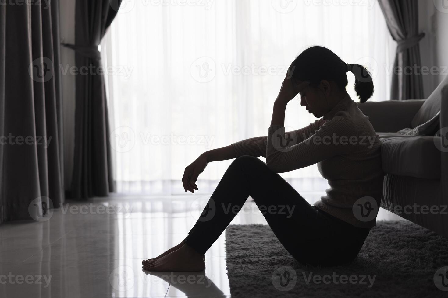 silhouette di un' persona sofferenza a partire dal depressione nel il Casa, depresso donna seduta solo su il divano sentire fatica, triste e preoccupato nel il buio camera. persona siamo stressato. foto