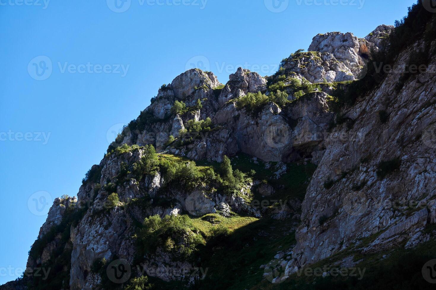 bellissimo scogliera sporgenze con erba e alberi contro il cielo foto