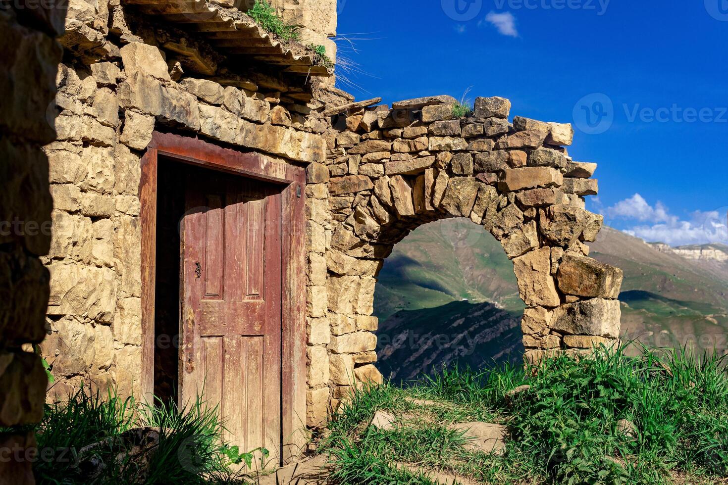 rovine di Casa nel il abbandonato villaggio di gamsutl prospiciente il montagne foto