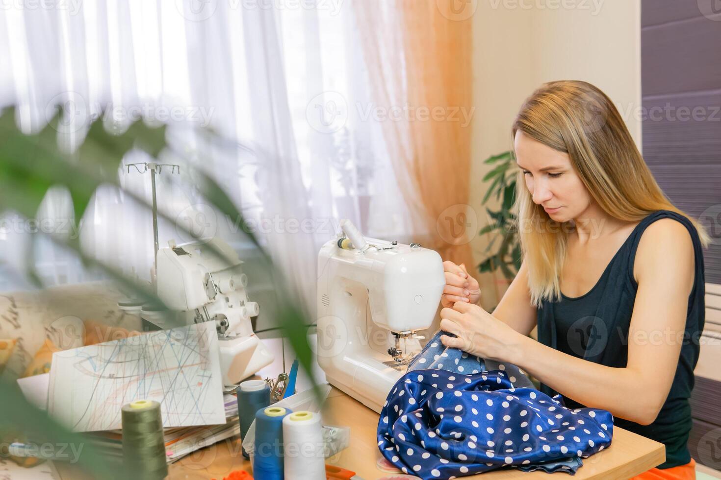 giovane donna cuce nel sua camera foto