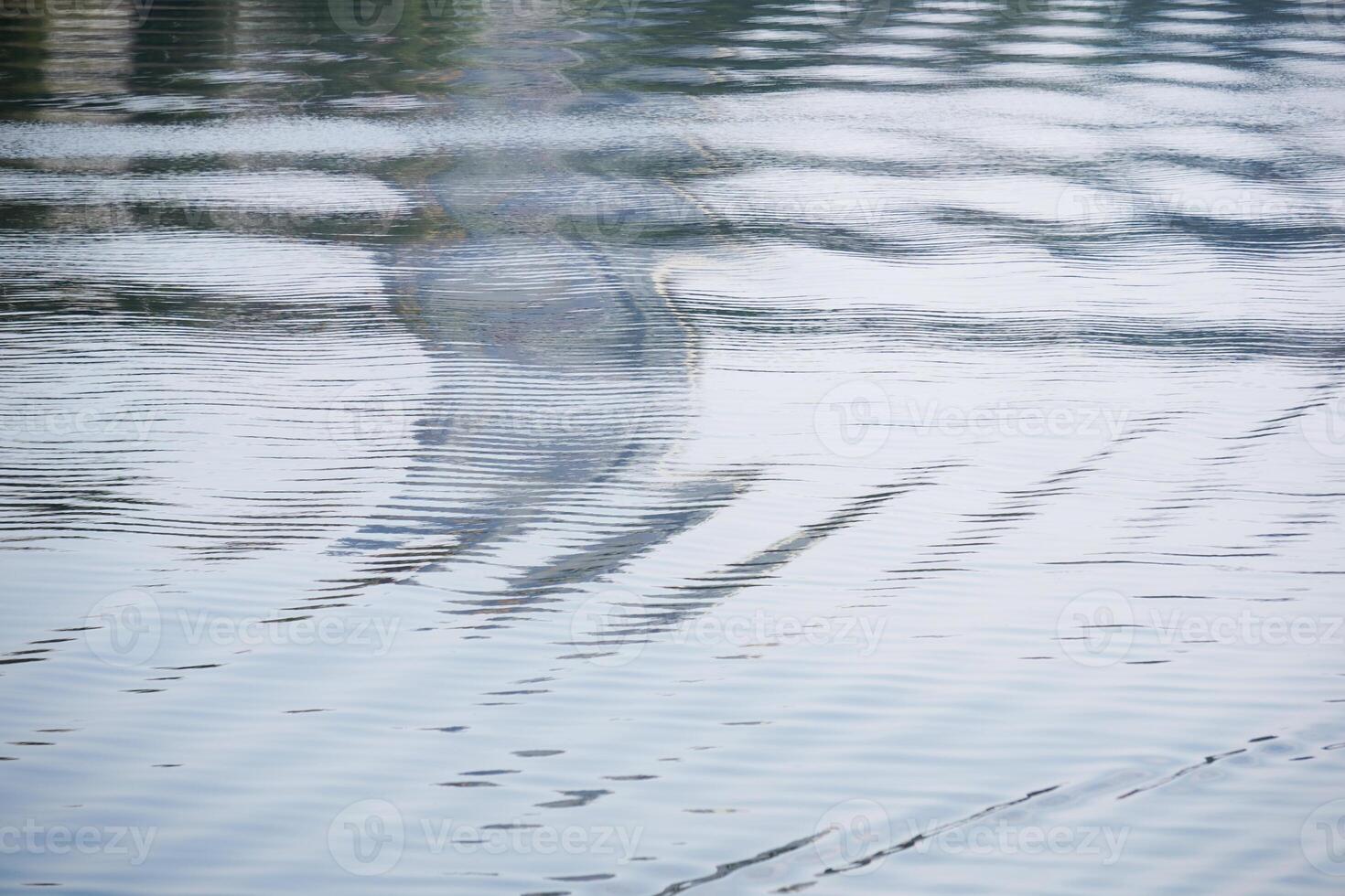 sfocato astratto sfondo - onde su il acqua superficie con iridescente sfocato riflessione foto