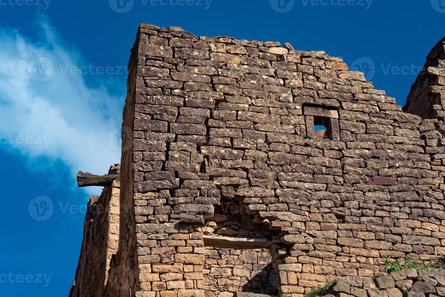 rovine di pietra muri contro il cielo nel il antico abbandonato villaggio di gamsutl foto