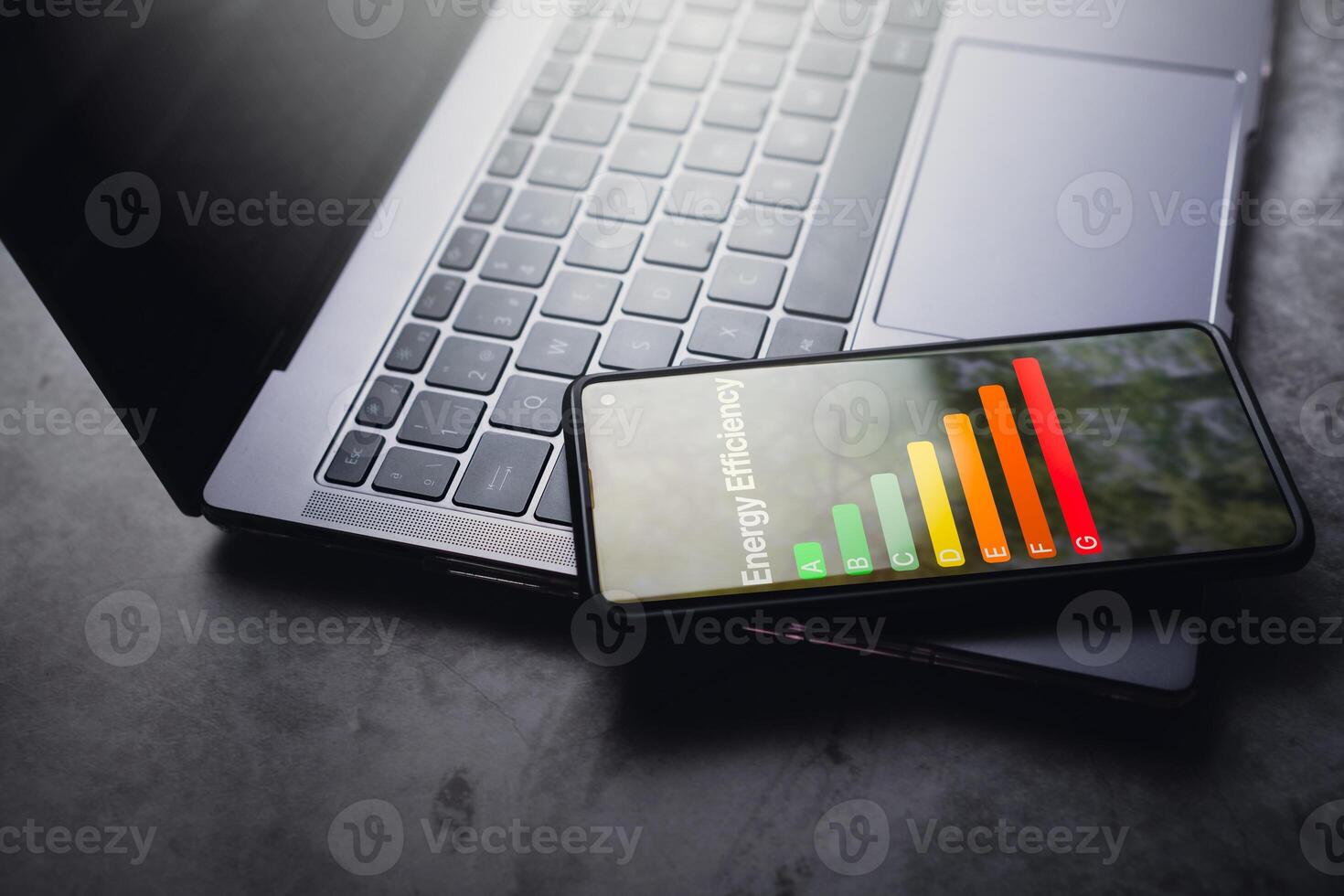 smartphone riposo su il computer portatile con Vota energia efficienza e eco casa rinnovamento interfaccia su schermo. Basso consumo ecologico Casa, sostenibile sviluppo concetto. foto