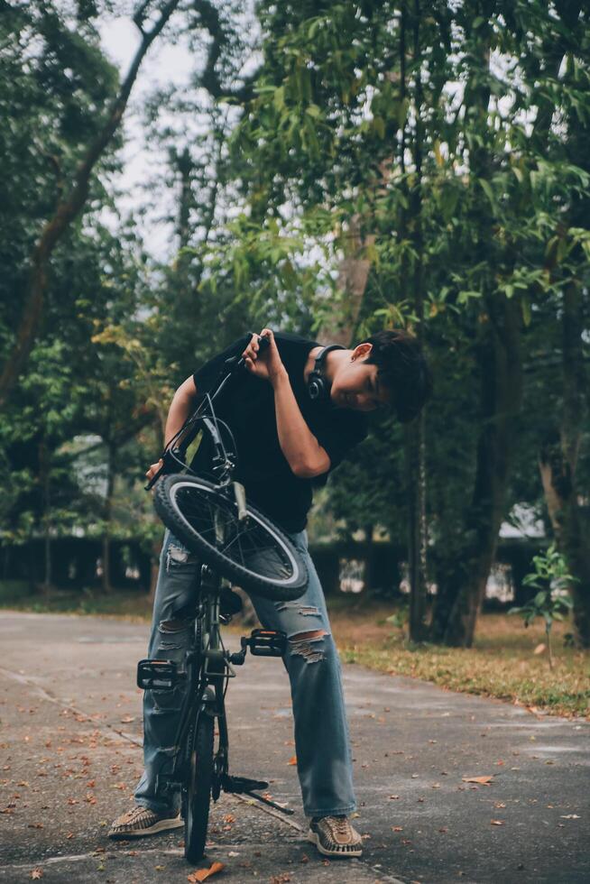 giovane bello barbuto uomo assunzione un' rompere mentre in viaggio il città con il suo bicicletta utilizzando il suo digitale tavoletta guardare lontano pensieroso foto