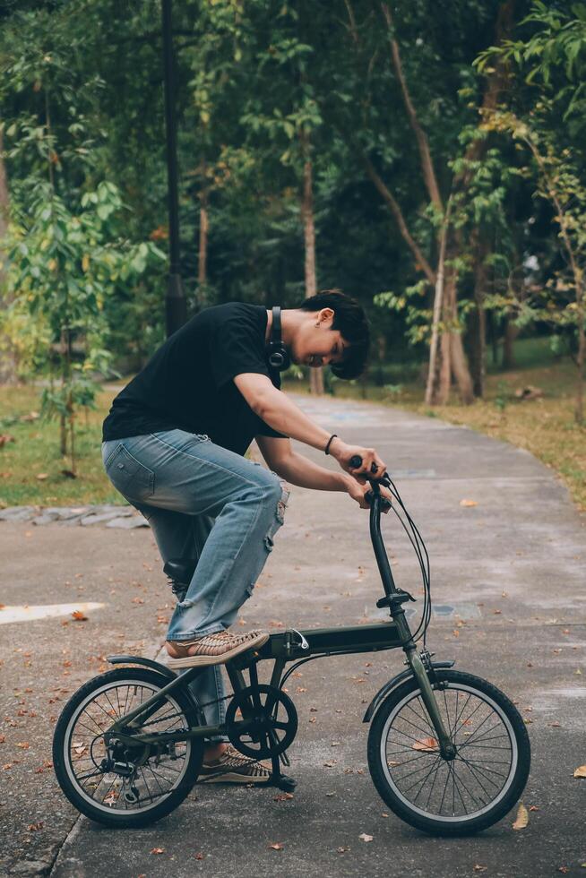 giovane bello barbuto uomo assunzione un' rompere mentre in viaggio il città con il suo bicicletta utilizzando il suo digitale tavoletta guardare lontano pensieroso foto