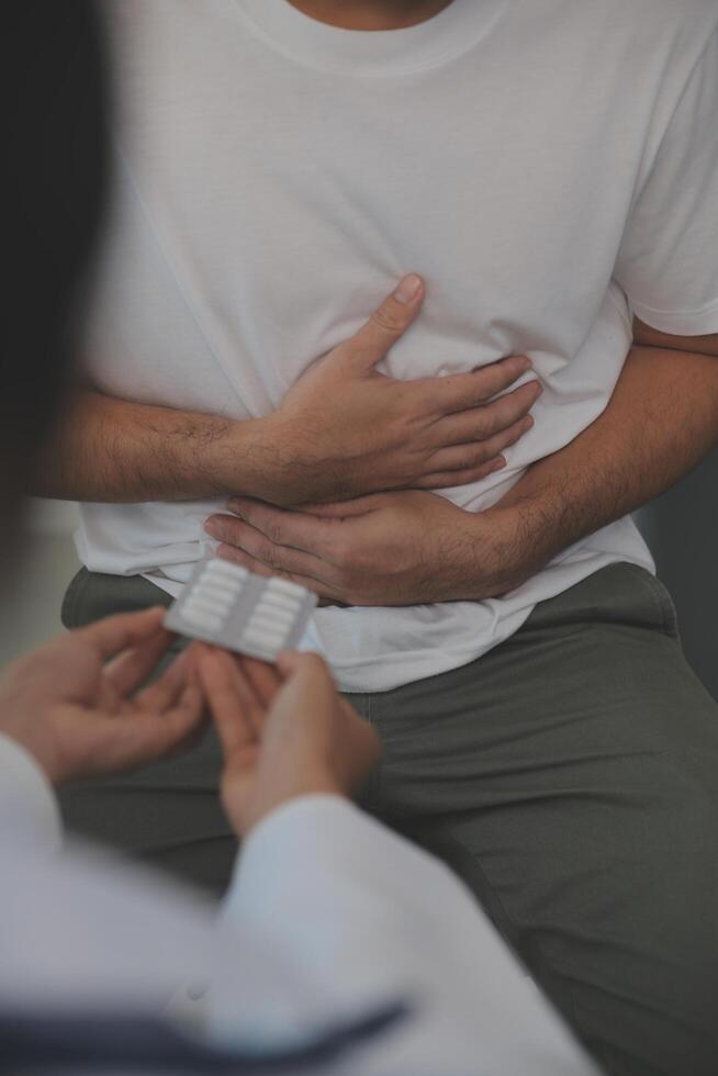 uomo sofferenza con acuto stomaco dolore seduta a casa. mano di maturo tipo Tenere addome sofferenza a partire dal dolore, diarrea o indigesto problema. caucasico tipo urgente su pancia su doloroso sensazione foto