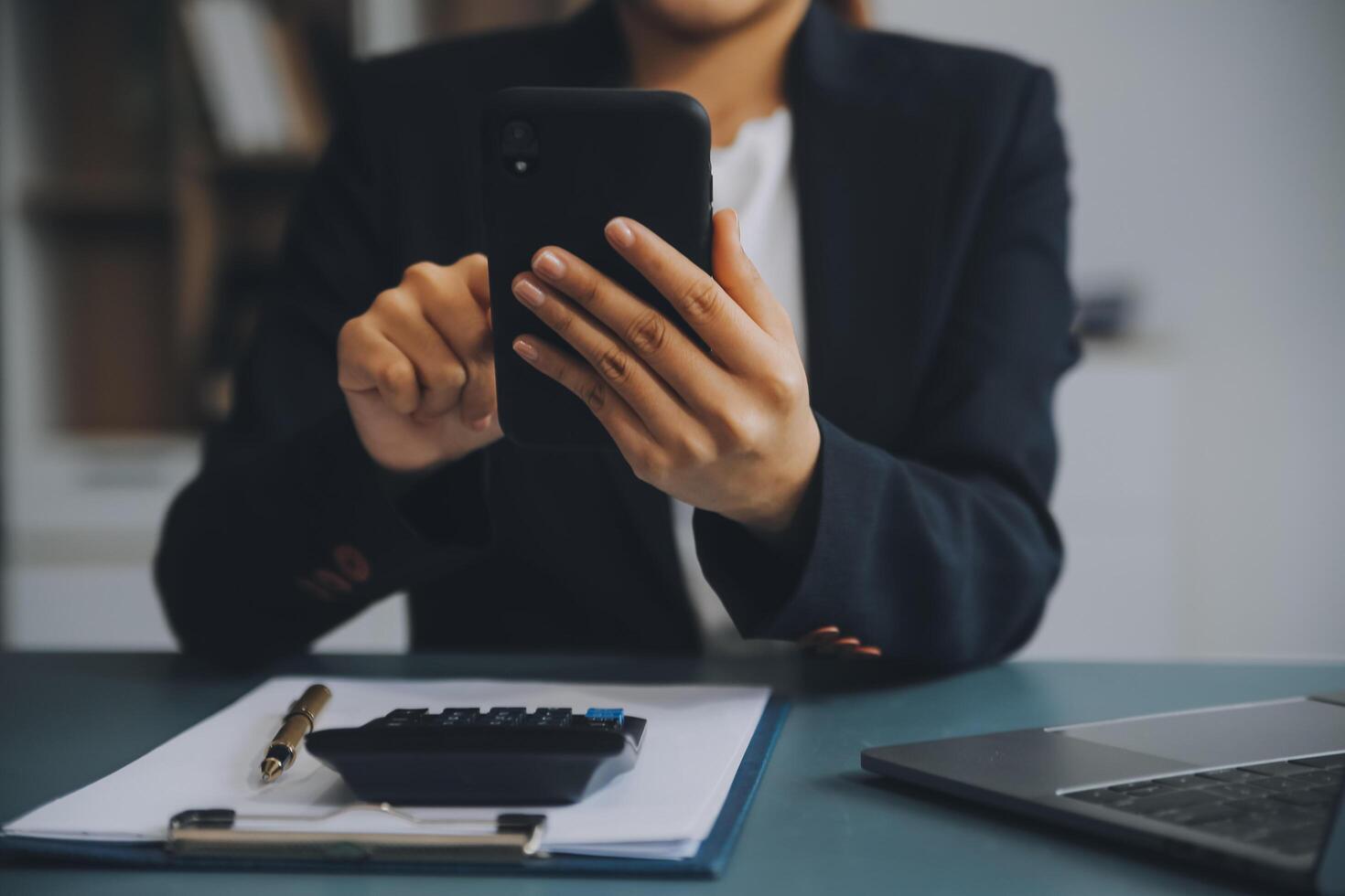 ispanico donna d'affari nel formale abbigliamento nel sua ufficio contento e allegro mentre utilizzando smartphone e Lavorando. giovane donna d'affari utilizzando applicazioni su cellula telefoni, lettura notizia, veloce connessione foto