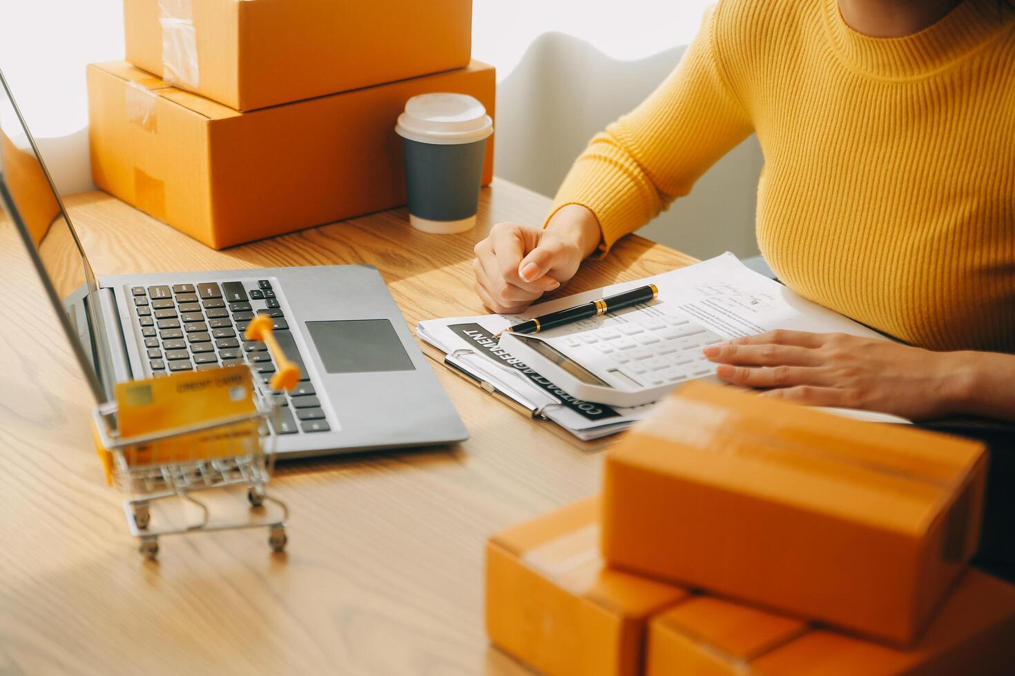 giovane donna piccolo imprenditore shopping online a casa. prendere nota degli ordini dei clienti con telefoni cellulari. piccolo imprenditore o concetto di stile di vita freelance. foto