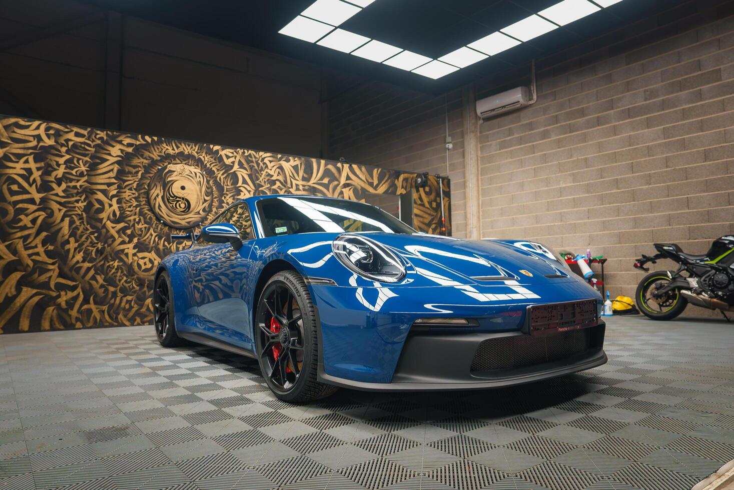 blu porsche 911 gt3 con artistico murale fondale nel moderno box auto foto